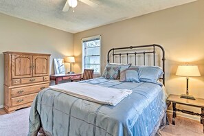 Un dormitorio con cama, cómoda de madera, escritorio y ventana.