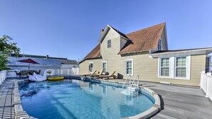 A swimming pool with a wooden deck, a white fence, and a house with a brown roof. - Charming Wildwood Hideaway w/ Private Pool & Deck! (Wildwood)