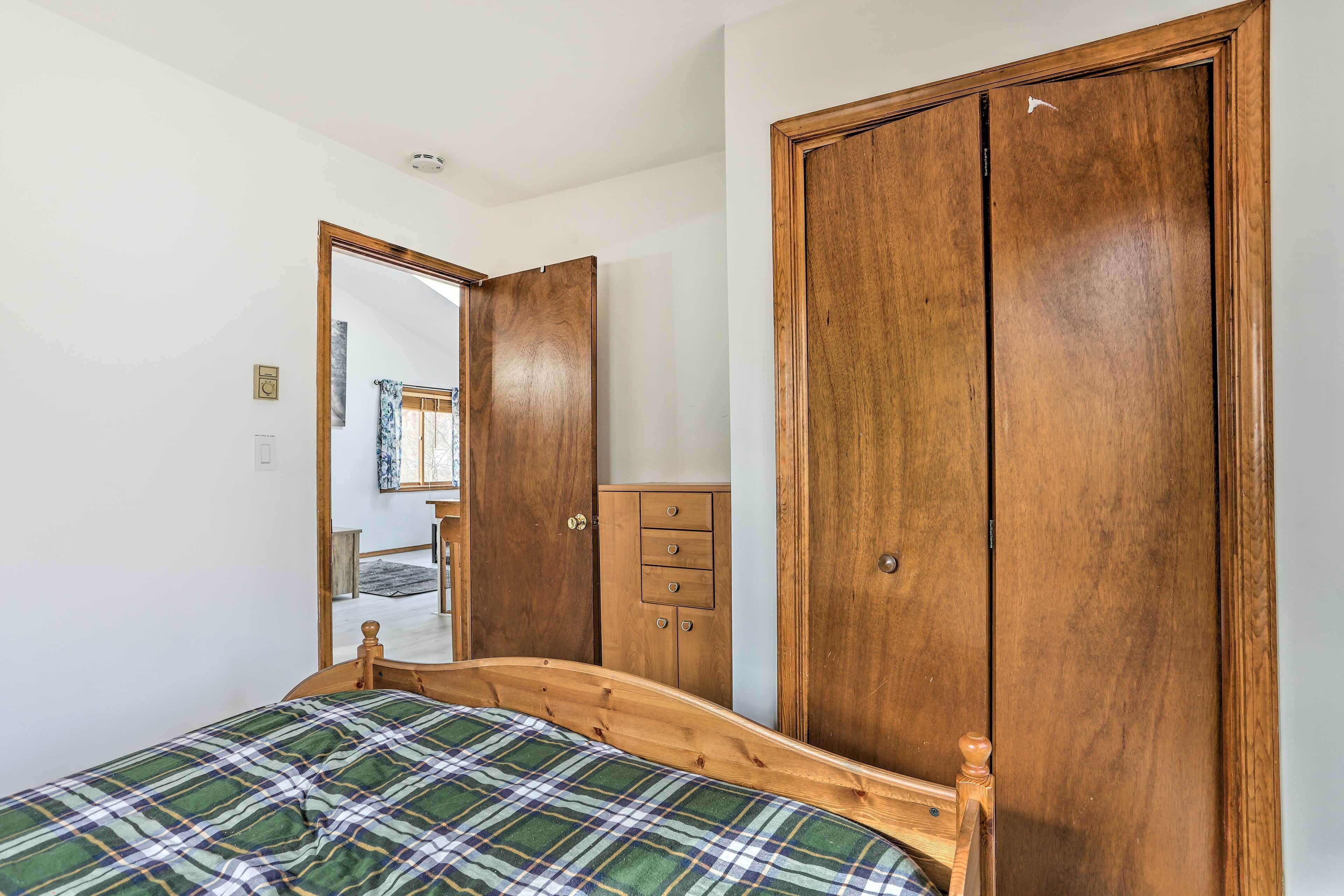 Een slaapkamer met een houten bed, een kledingkast en een dressoir.