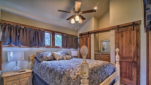 A bedroom with a bed, nightstand, dresser, and a ceiling fan.