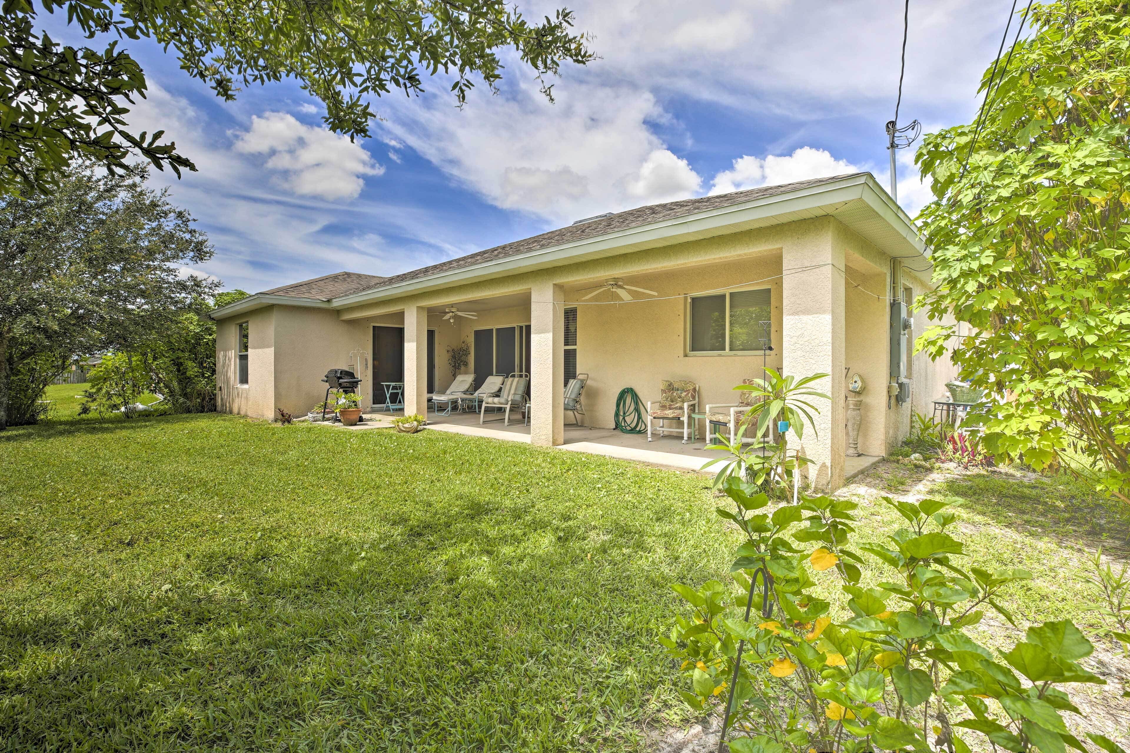 A single-story house with a covered porch, a lawn, and a garden.
