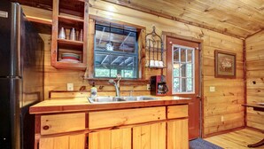 A wooden cabin kitchen with a refrigerator, sink, and wooden cabinets. - Private Broken Bow Cabin w/ Hot Tub + Gazebo! (Broken Bow)