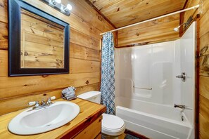 A wooden cabin bathroom with a sink, toilet, and bathtub. - Private Broken Bow Cabin w/ Hot Tub + Gazebo! (Broken Bow)