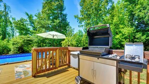 An outdoor deck with a grill, a small refrigerator, and a pool. - Browns Summit Vacation Rental w/ Fire Pit! (Browns Summit)