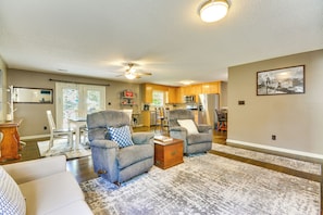 A living room with two gray armchairs, a white sofa, a wooden coffee table, and a patterned rug. - Browns Summit Vacation Rental w/ Fire Pit! (Browns Summit)