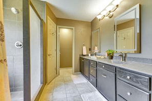 A bathroom with a shower, vanity, and a large mirror. - Browns Summit Vacation Rental w/ Fire Pit! (Browns Summit)
