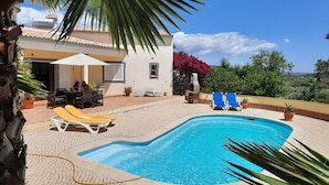 A swimming pool with lounge chairs, a patio area, and a view of the surrounding landscape. - Beautiful villa with private pool and sea view (foupana, moncarapacho)