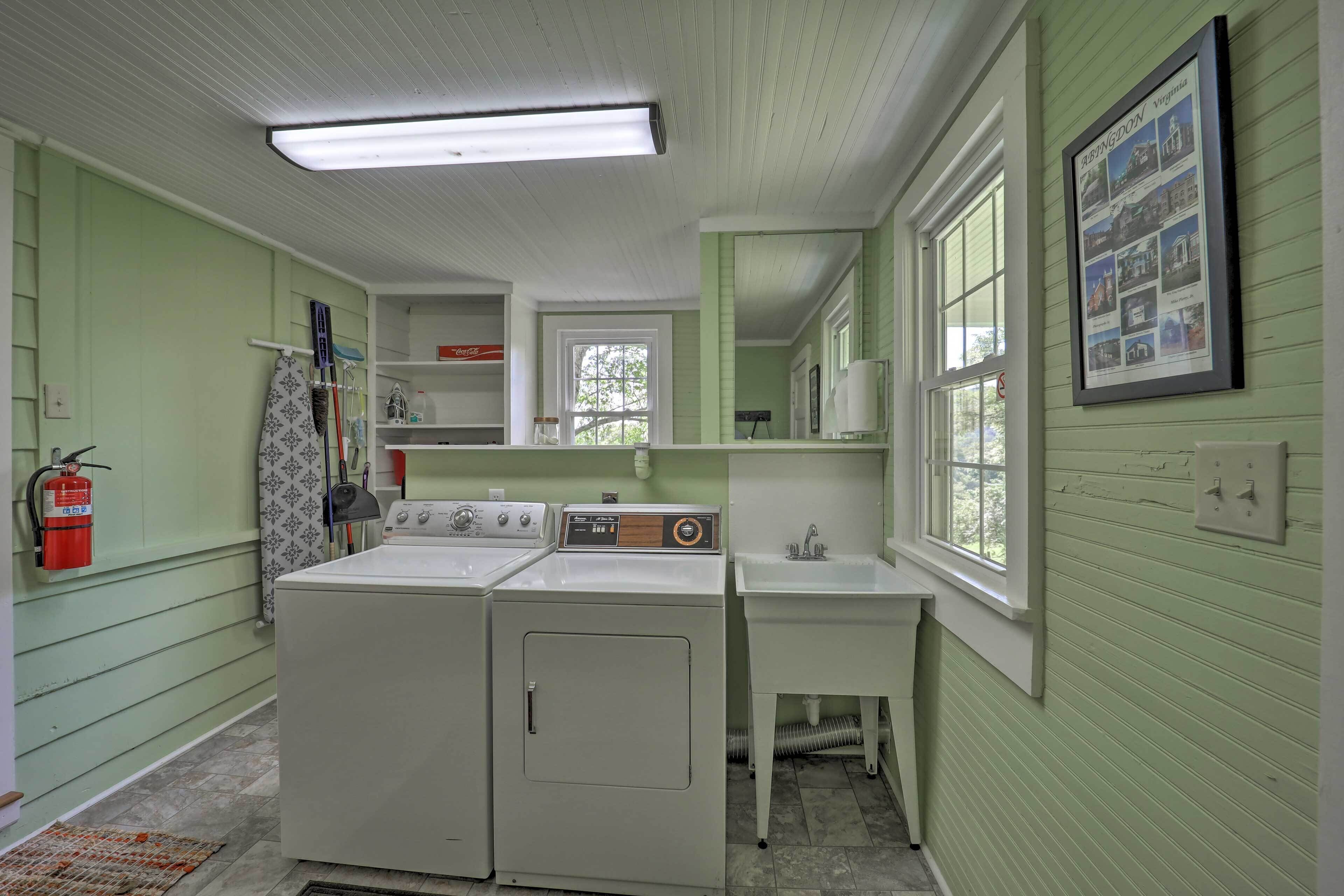 A laundry room with two washing machines, a sink, and a fire extinguisher.