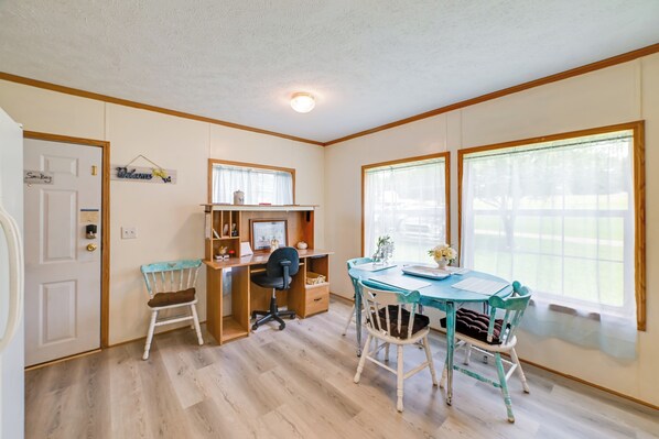 A room with a wooden desk, two chairs, a computer, and a window with a view of a fence. - Warm & Inviting Family Home - 2 Mi to Golf Course! (McEwen)