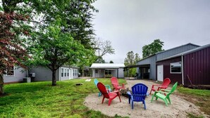 Un pati darrere amb una xemeneia exterior i cadiretes Adirondack.