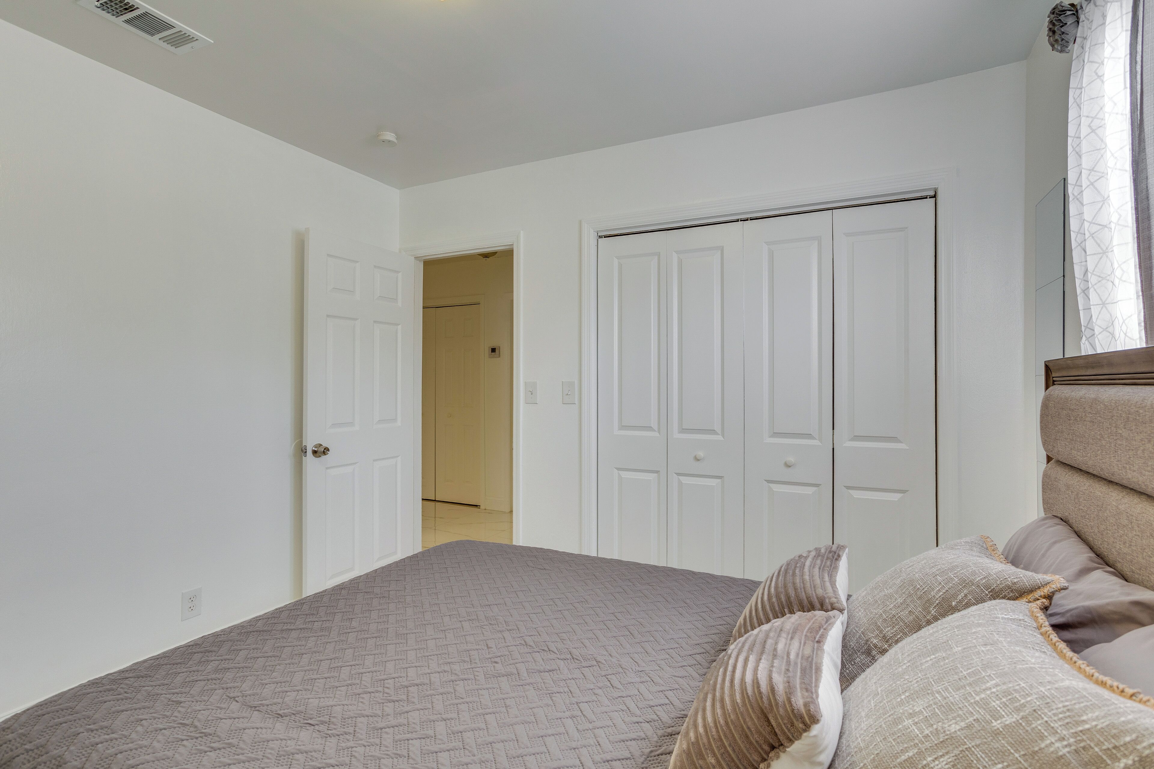 A bedroom with a bed, a door, and a closet.