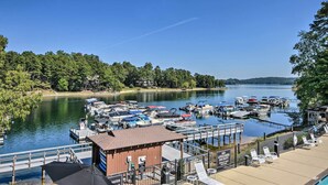 A marina with boats docked, a lifeguard station, and a view of a lake surrounded by trees. - Views, Pools & Marina: Lake Keowee Condo! (Salem)