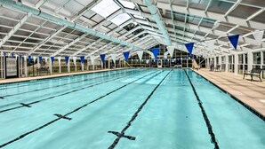 A large indoor swimming pool with clear lanes, a covered roof, and seating areas along the sides. - Views, Pools & Marina: Lake Keowee Condo! (Salem)