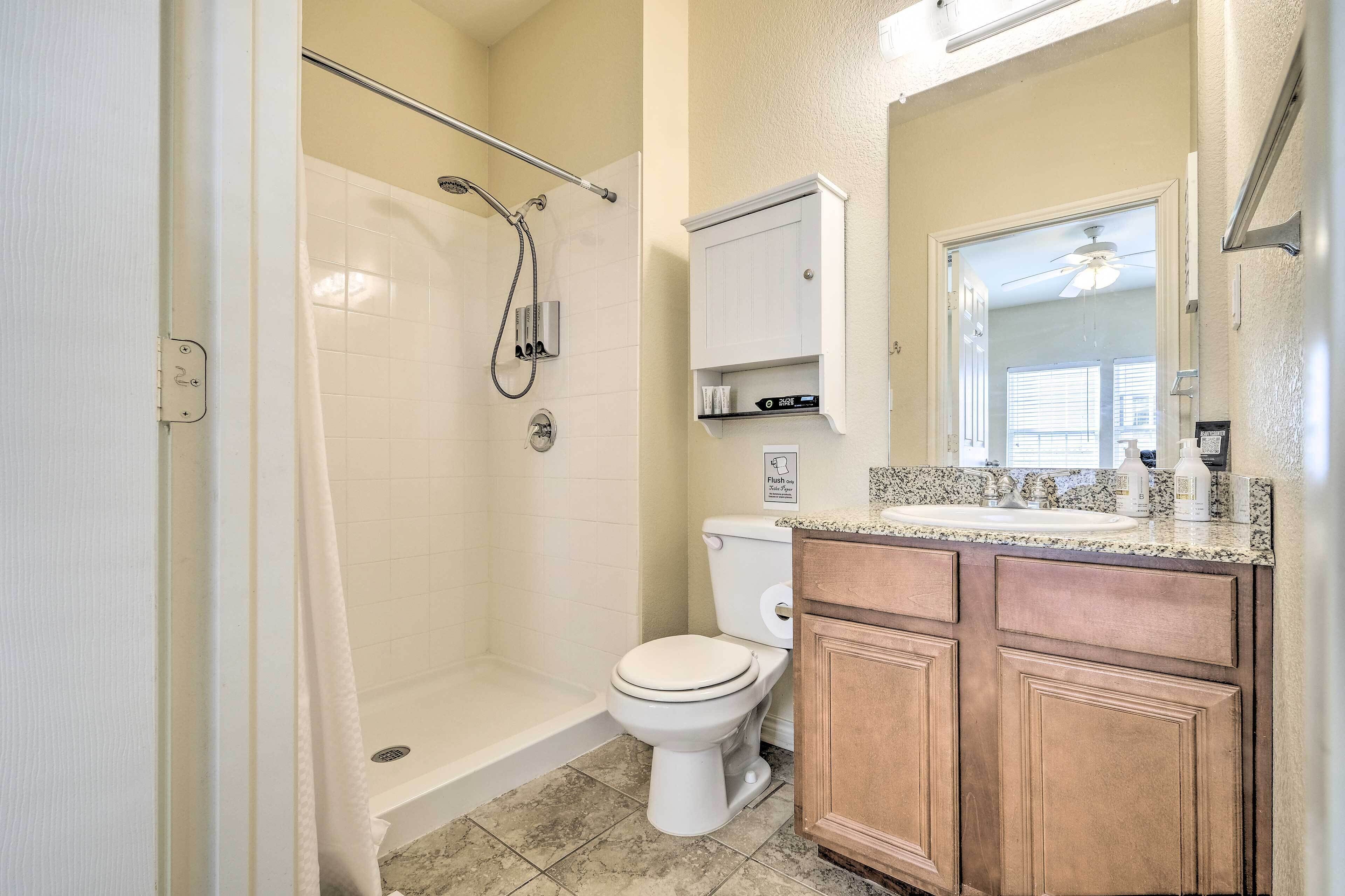 Une salle de bain avec douche, toilettes et lavabo.