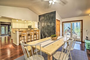 A spacious kitchen with wooden cabinets, a central island, and a dining area with a large table and chairs.