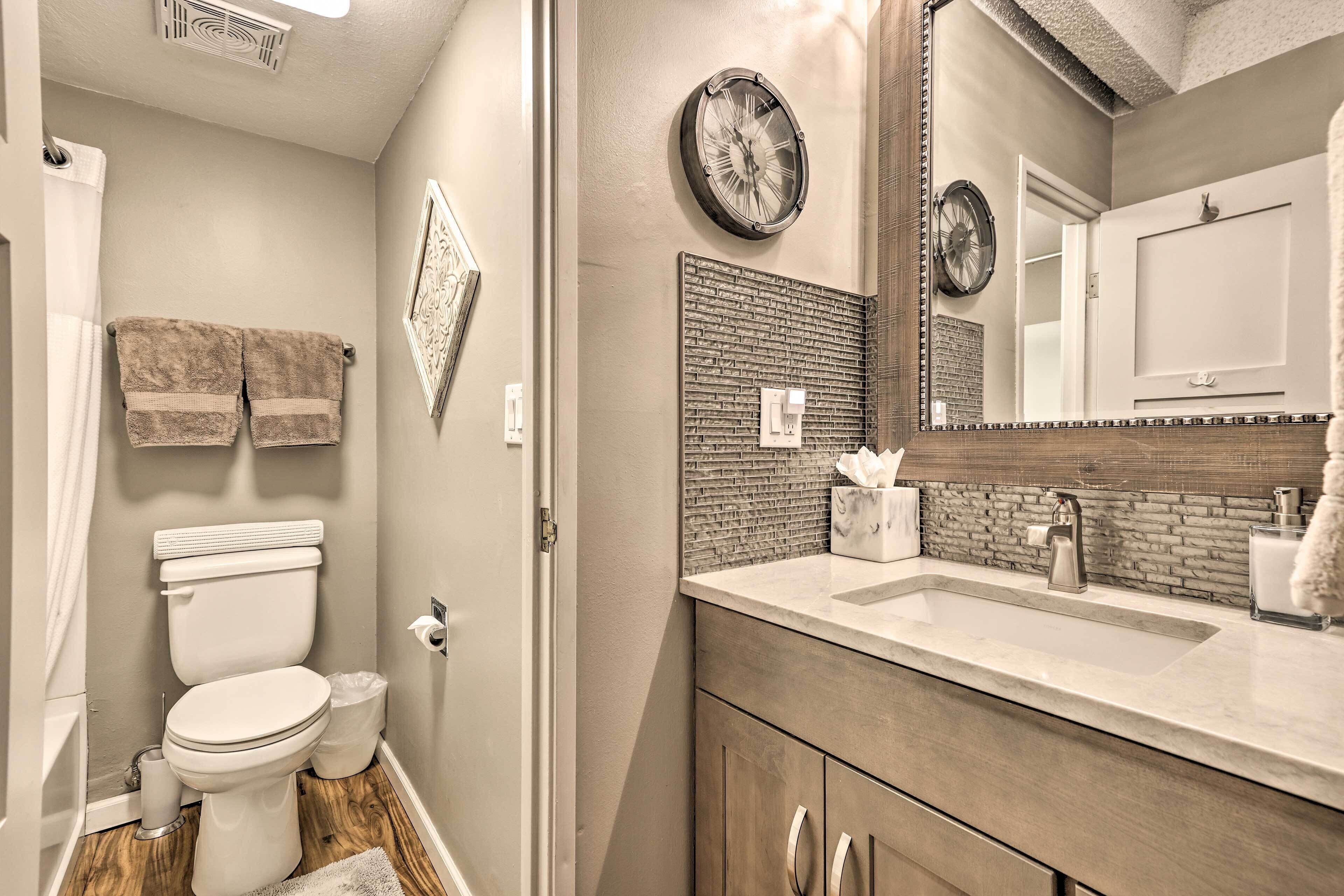 Une salle de bain avec des toilettes, un lavabo et un miroir.