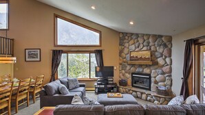 A living room with a stone fireplace, a television, and a dining area with wooden furniture. - Half-mi to Copper Mtn Slopes: Frisco Unit w/ Loft (Frisco)