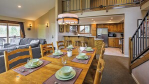 A dining area with a wooden table set for six, a kitchen in the background, and a staircase leading to an upper level. - Half-mi to Copper Mtn Slopes: Frisco Unit w/ Loft (Frisco)