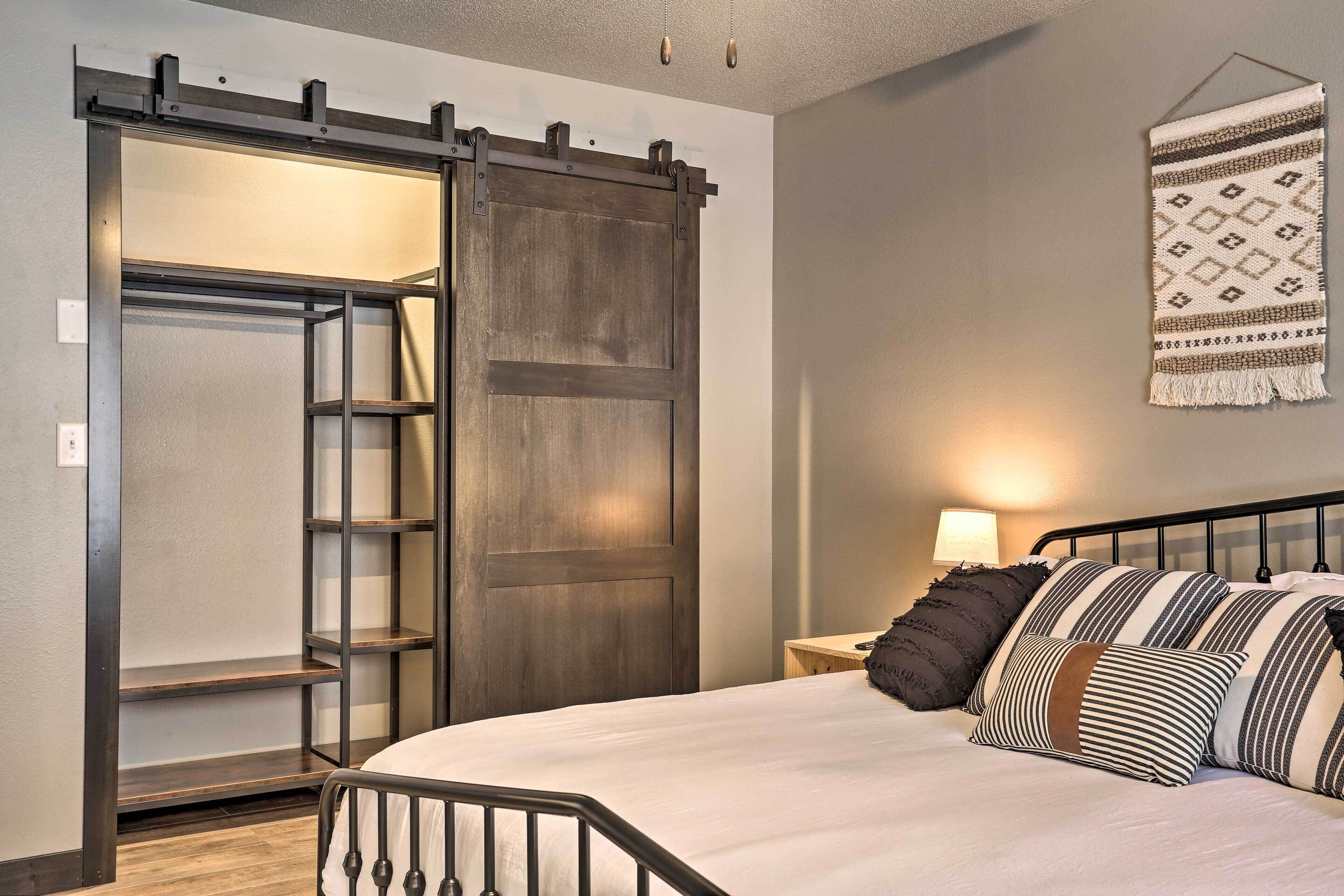 Quarto com cama, guarda-roupa, escada e tapeçaria na parede.