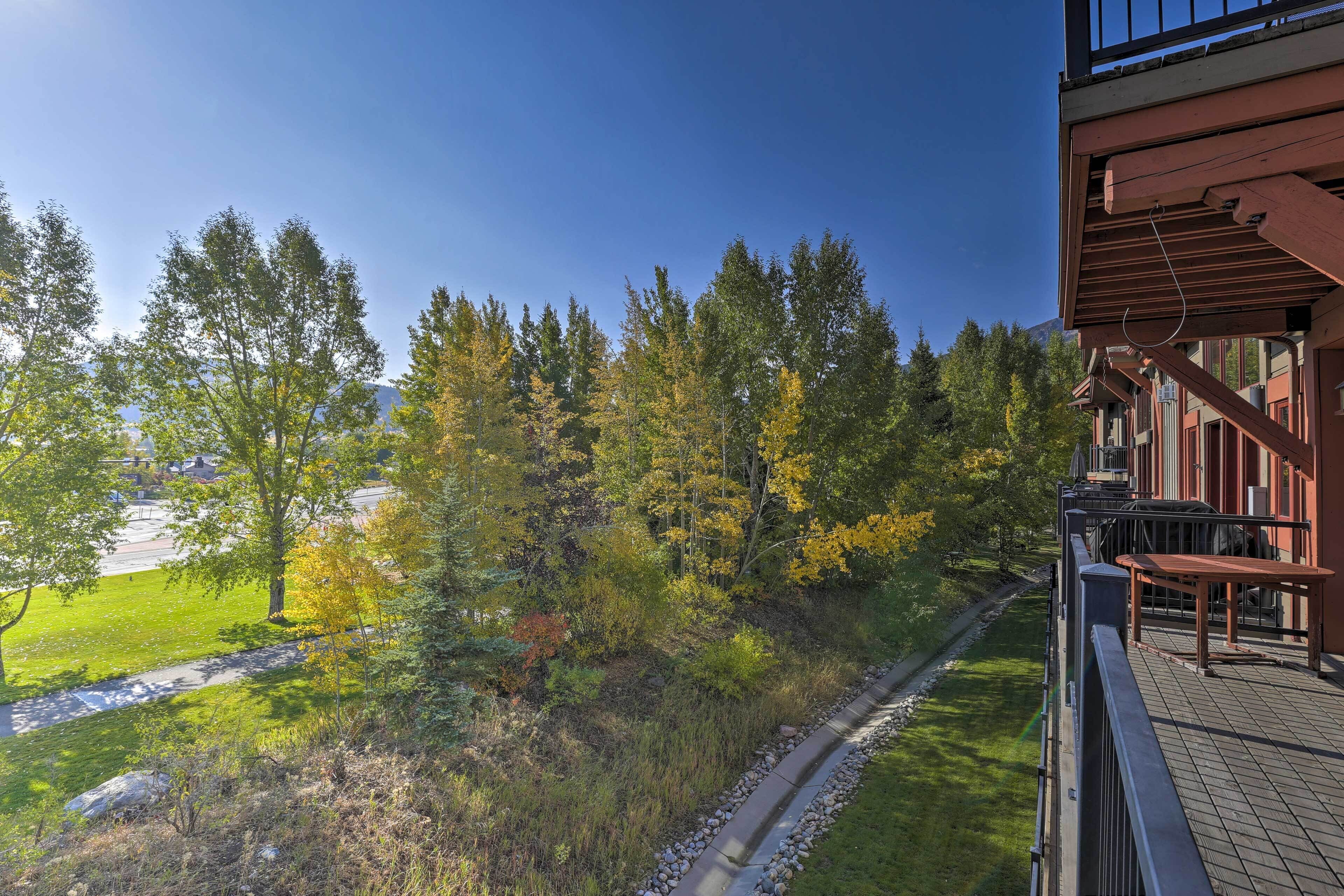 Un balcone con vista su una zona boschiva e un sentiero lastricato.