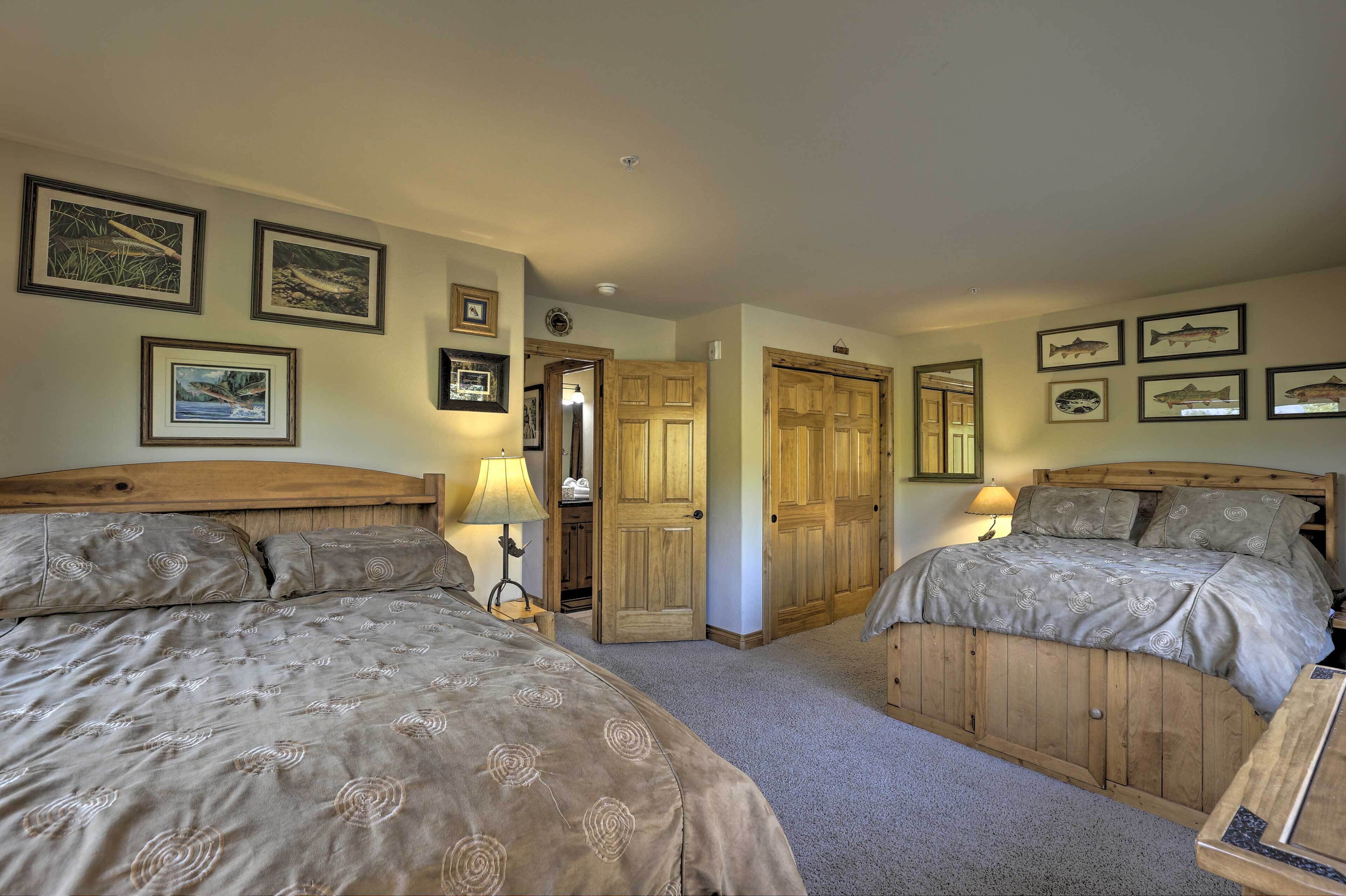 A bedroom with two beds, wooden headboards, and framed pictures on the walls.