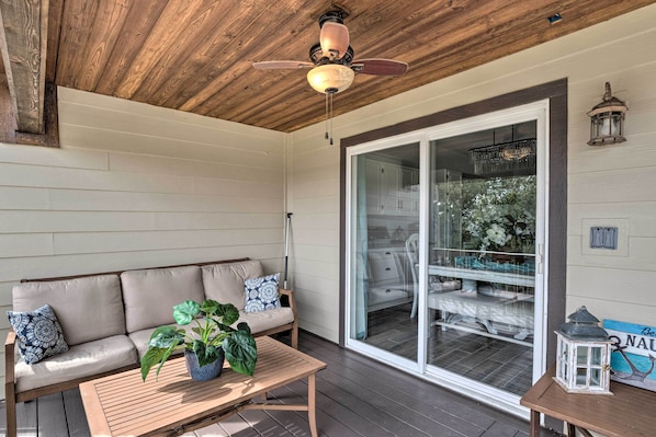 A wooden ceiling, a ceiling fan, a sliding glass door, a sofa, a table, and a potted plant. - Lakefront Resort Living: Pool, Golf, Tennis & More (Leander)