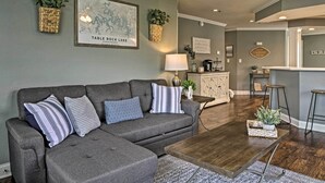 A living room with a gray sectional sofa, a wooden coffee table, and a map on the wall. - Branson Condo: Pool Access, Near Table Rock Lake! (Branson)