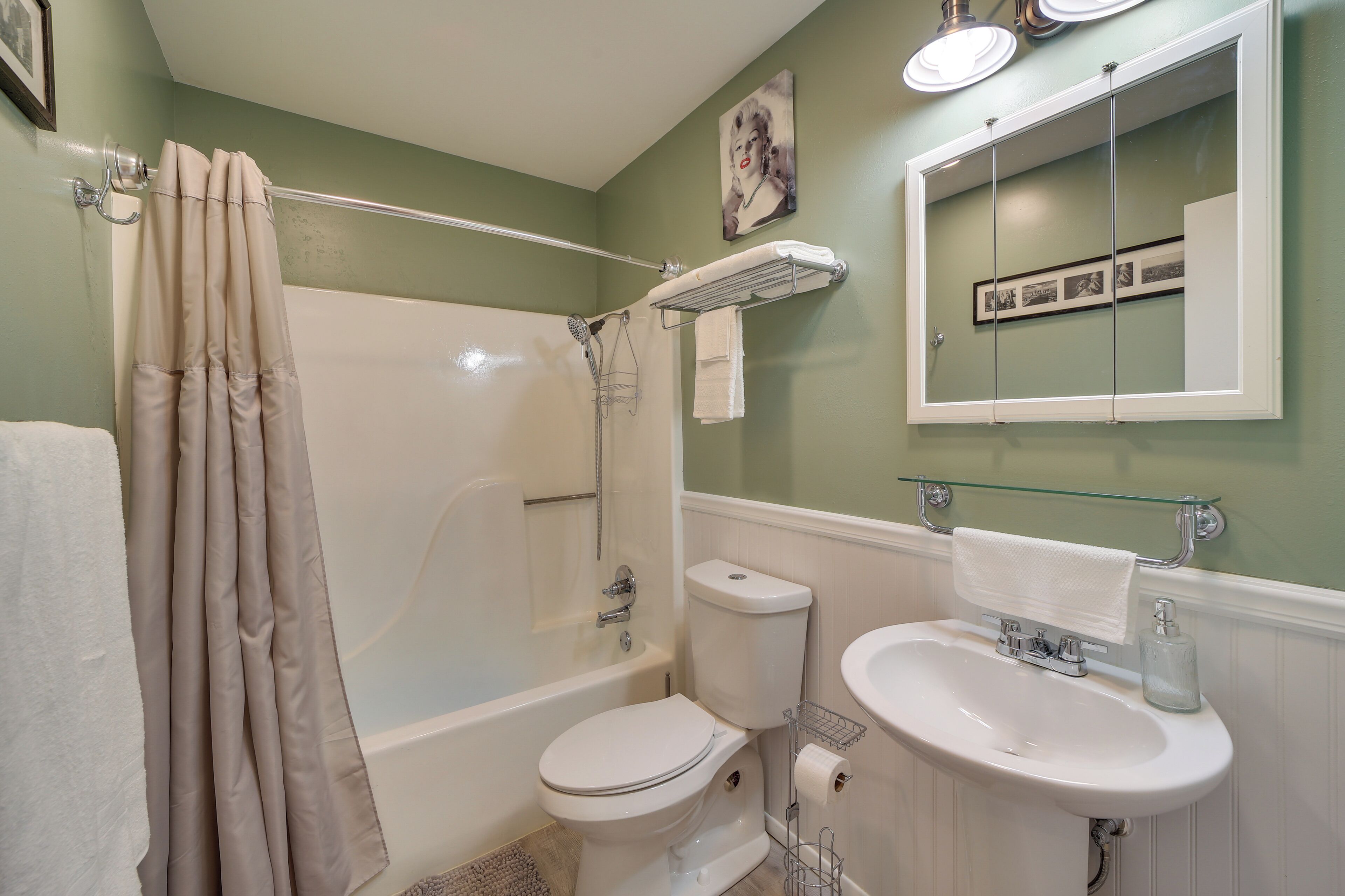 A bathroom with a bathtub, toilet, and sink.