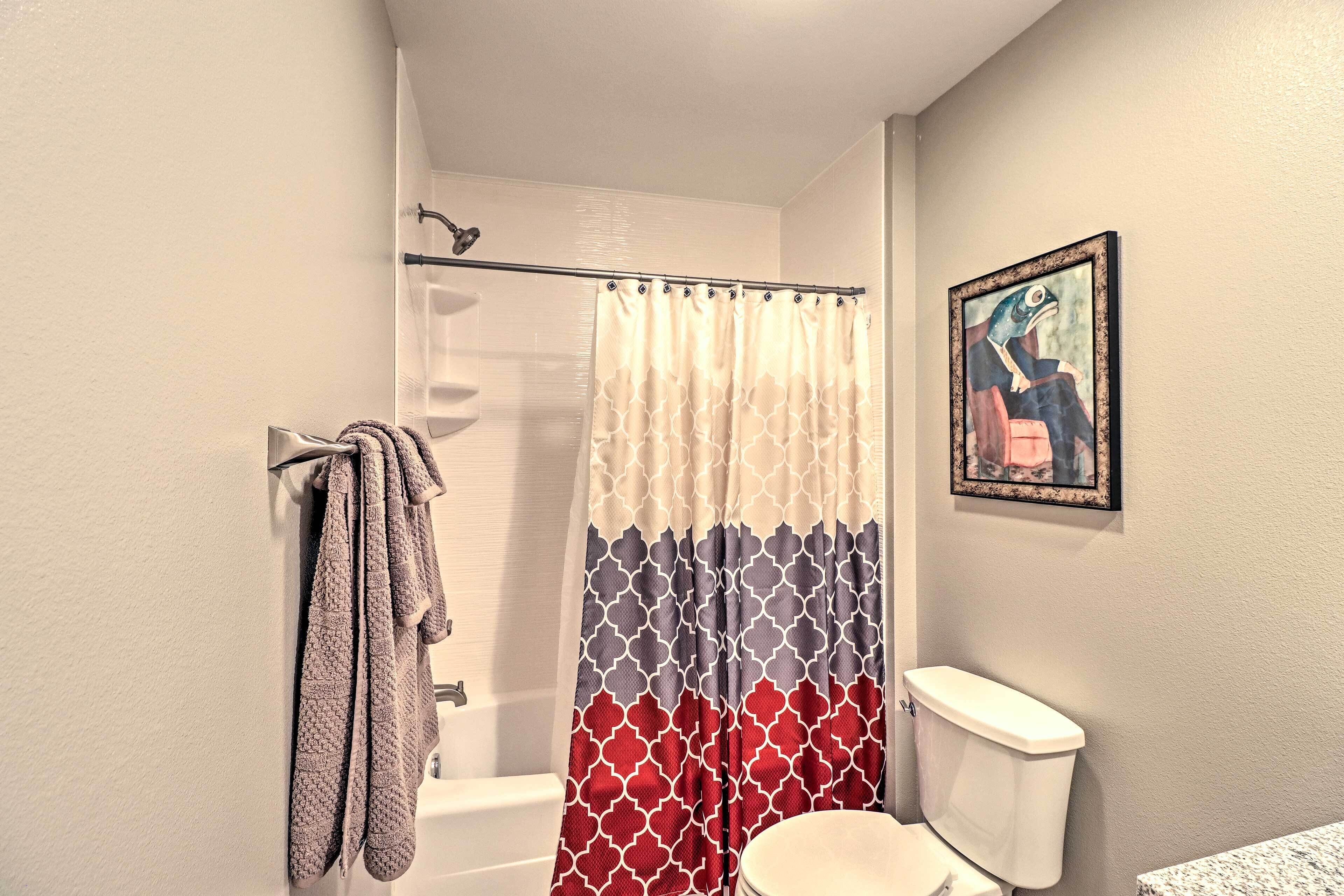 Ein Badezimmer mit Duschvorhang, Toilette und Handtuchhalter.