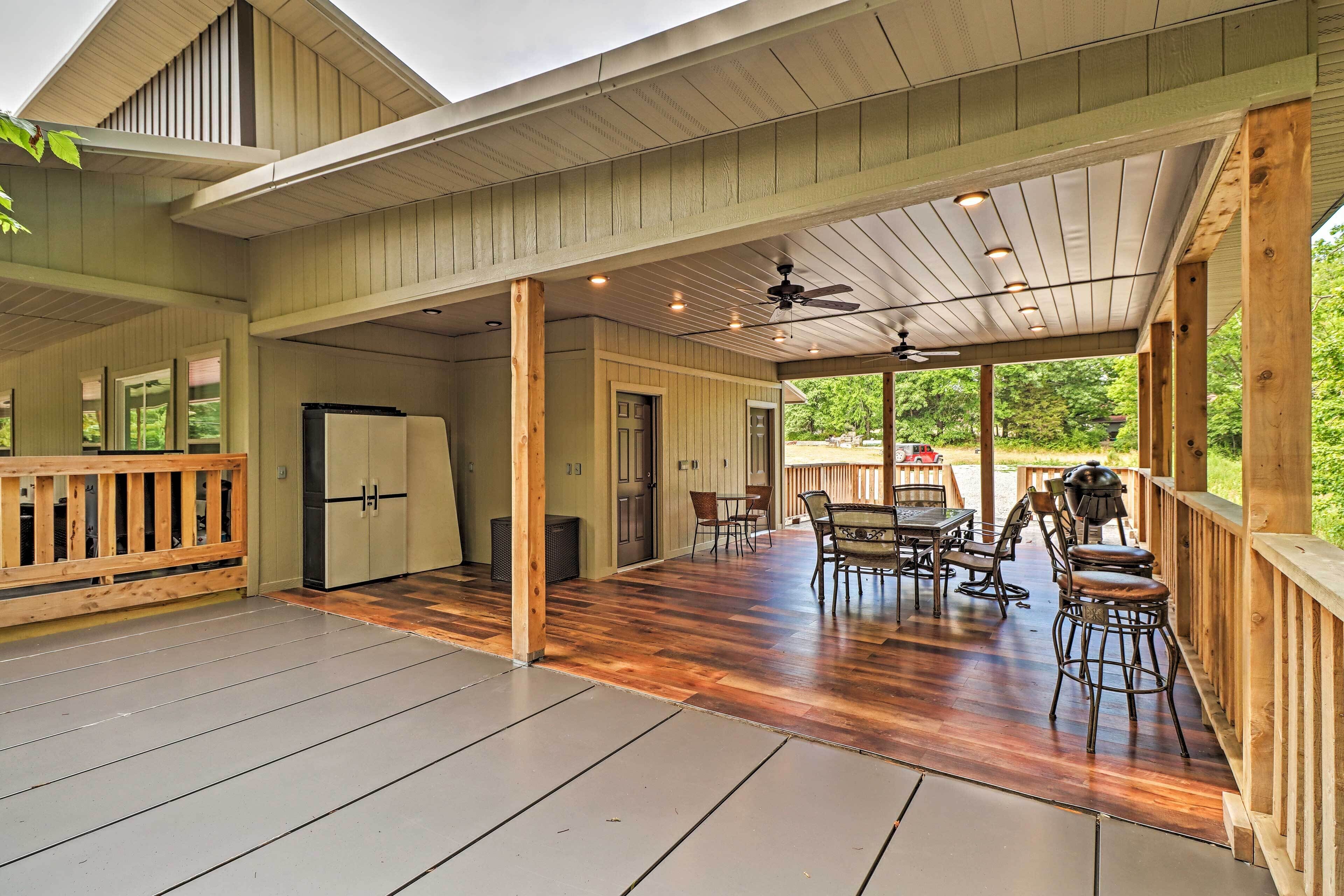 A covered patio with wooden flooring, a ceiling fan, and a dining area with chairs and a table.