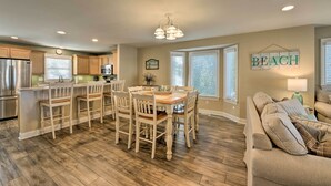 A spacious kitchen with a dining area, wooden flooring, and a beach-themed wall decoration. - Wildwood Townhome w/ Patio: 1 Block To The Beach! (Wildwood)