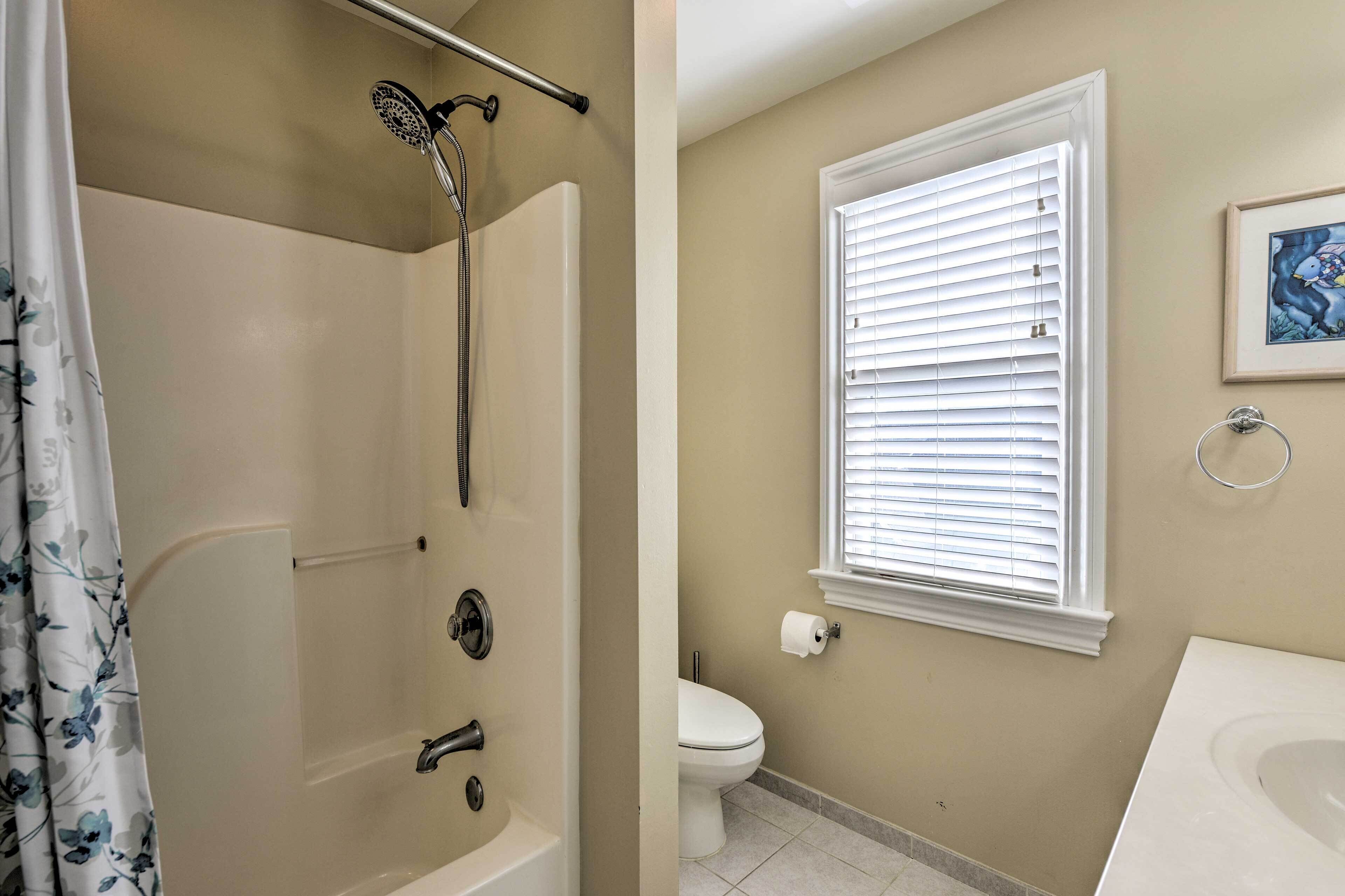 A bathroom with a bathtub, toilet, and sink.