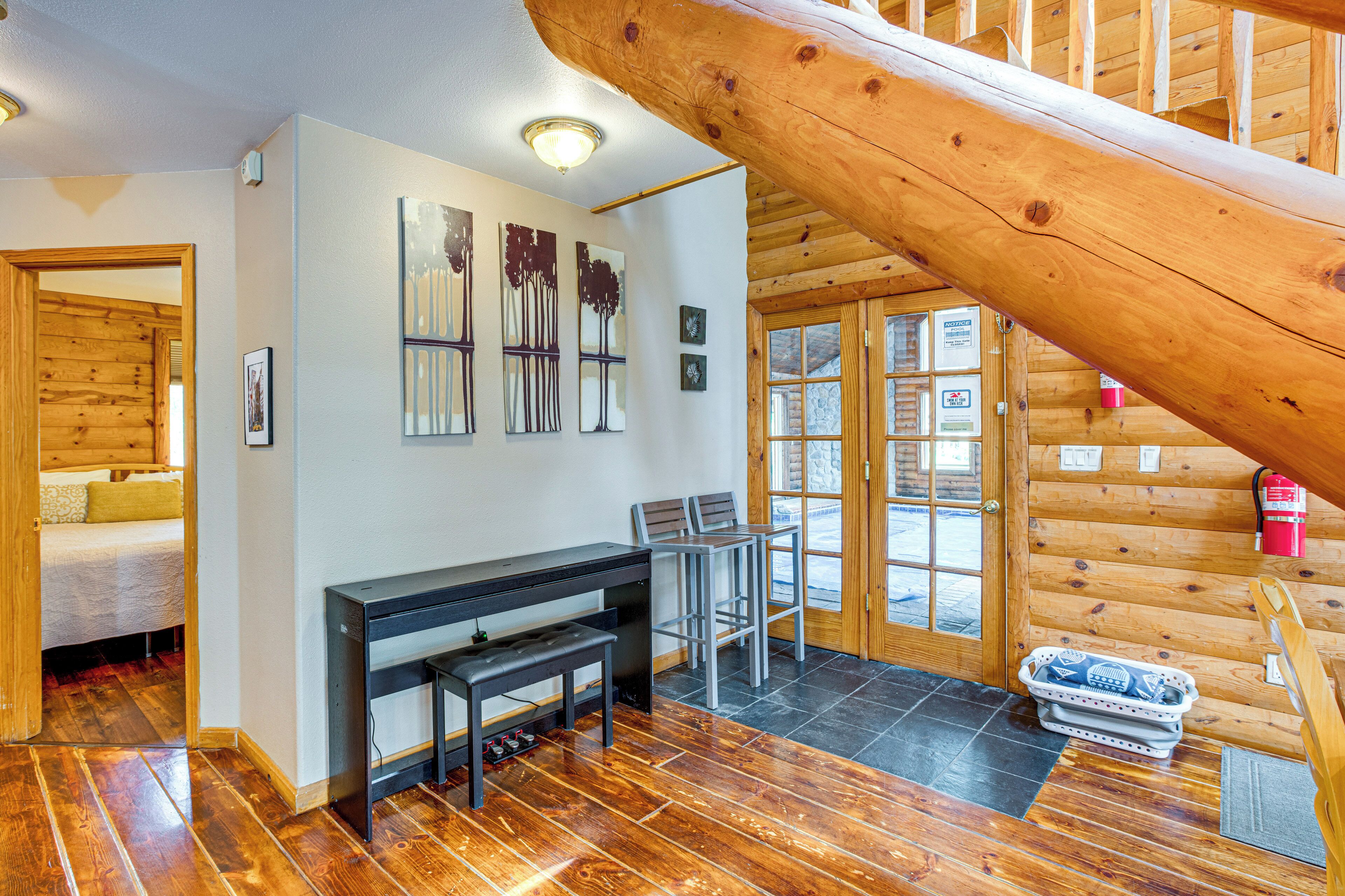 Interior de madera con escalera, zona de comedor y cama.