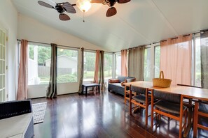 Une pièce spacieuse comprenant une table à manger, des chaises, un canapé et un ventilateur de plafond.