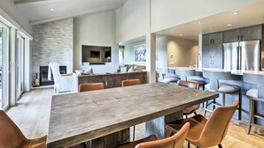 A modern kitchen with a large island, stainless steel appliances, and a dining area with a wooden table and leather chairs. - Tasteful Snowmass Escape < 1 Mi to Slopes! (Snowmass Village)