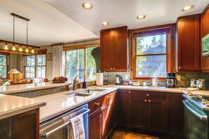 Una cocina con armarios de madera, un lavamanos de acero inoxidable y un horno empotrado.