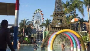 A water park with an Eiffel Tower replica, a Ferris wheel, and a colorful water slide.