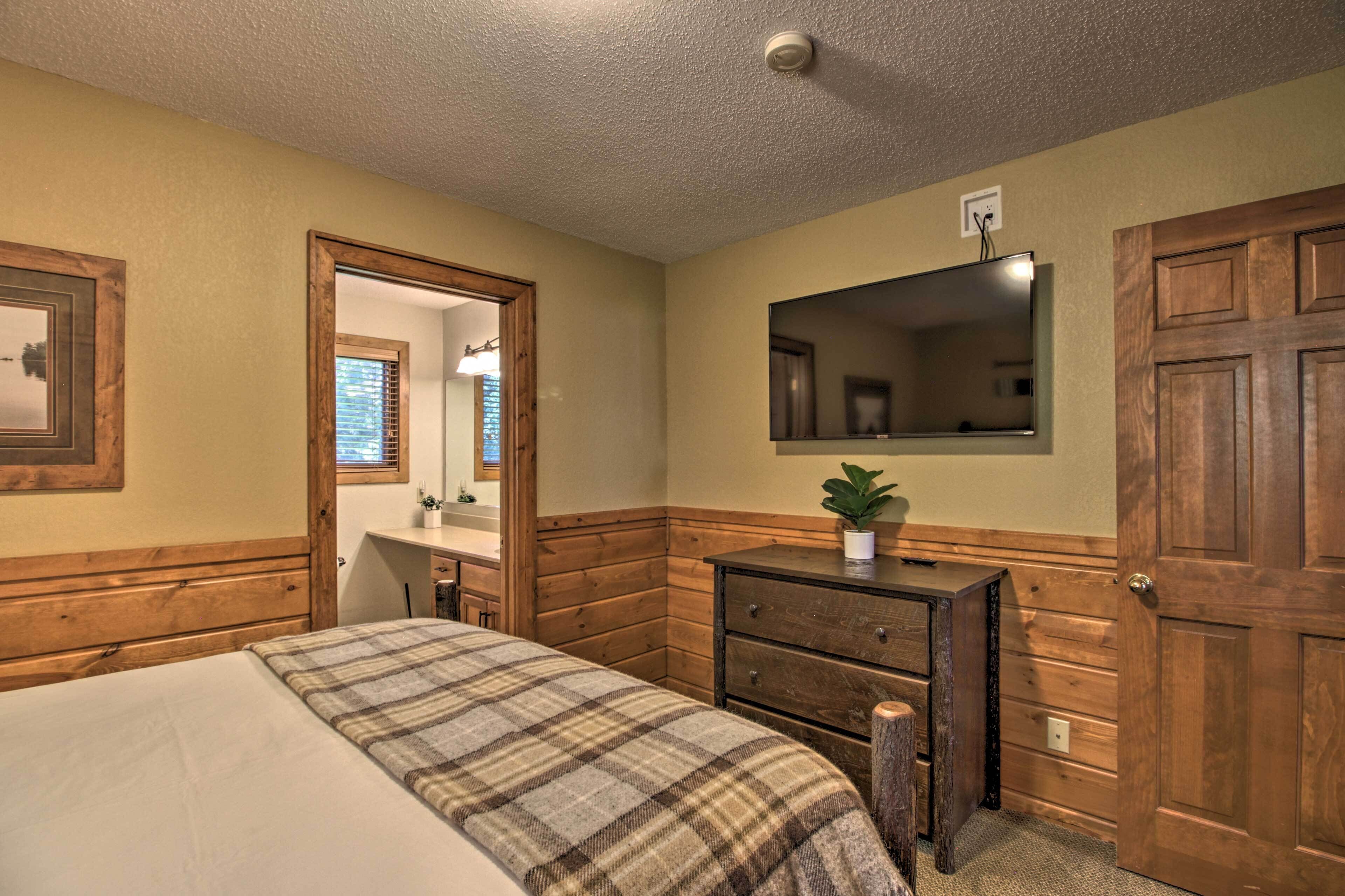 Un dormitorio con una cama, un aparador de madera y un espejo en la pared.
