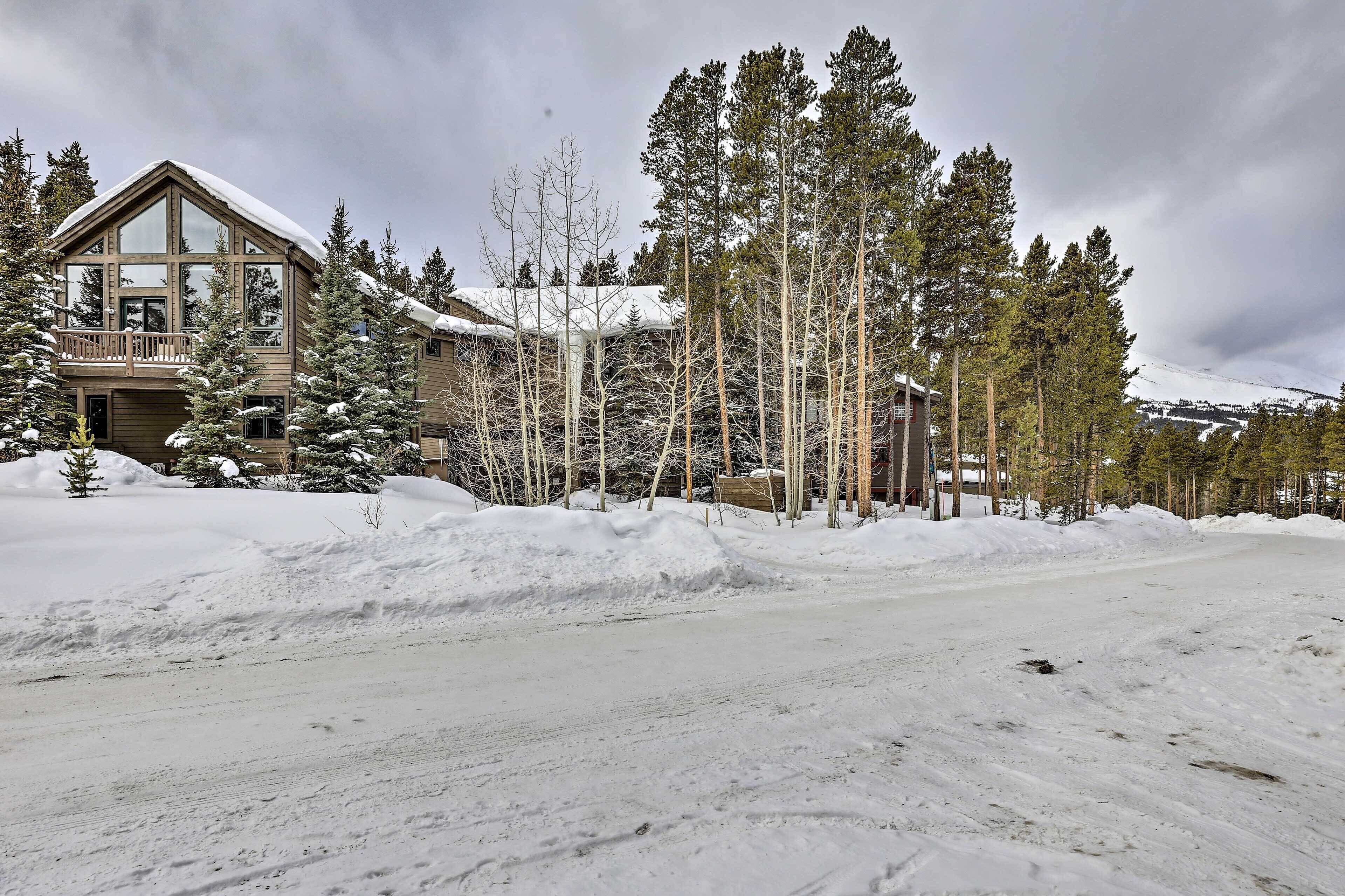 A large lodge with a prominent balcony and snow-covered trees.