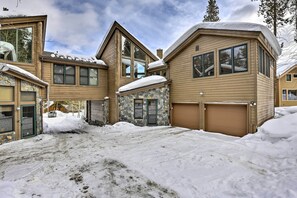 A large, multi-story house with a stone foundation and multiple garage doors.