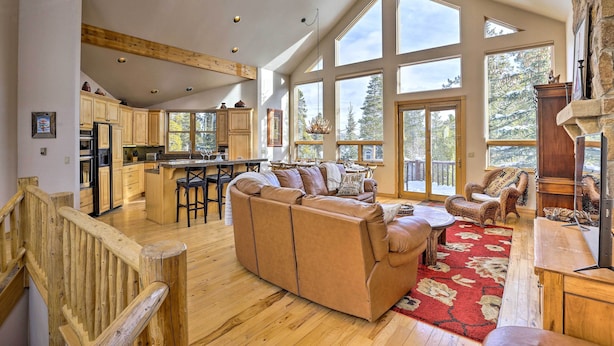 A spacious living area with a large sofa, wooden flooring, and a fireplace.