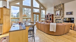 A spacious living area with a large stone fireplace, a built-in TV, and a cozy seating area.