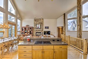 A spacious kitchen with a large island, wooden cabinets, and a stone fireplace. - Ski-in/out Breckenridge Gem w/ Hot Tub! (Breckenridge)