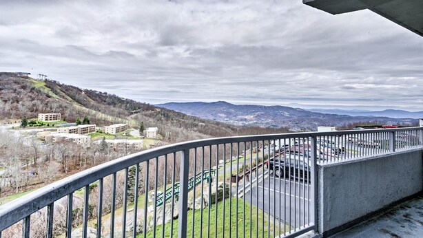 A balcony with a view of a parking lot and buildings in the distance. - Sugar Mountain Resort Condo w/ Pool Table & Views! (Banner Elk)
