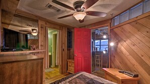 A bedroom with a bed, a wooden desk, a red door, and a ceiling fan. - Sugar Mountain Resort Condo w/ Pool Table & Views! (Banner Elk)