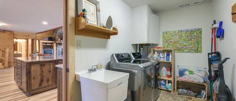 A compact kitchen with a sink, washing machine, and a small dining area.