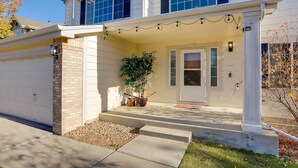 A two-story house with a front porch, a garage, and a potted plant. - Spacious Thornton Home: 15 Mi to Downtown Denver! (Thornton)
