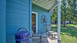A blue house with a porch, a metal star decoration, and two metal chairs. - Resort Condo in Pottsboro w/ Lake Texoma Access! (Pottsboro)