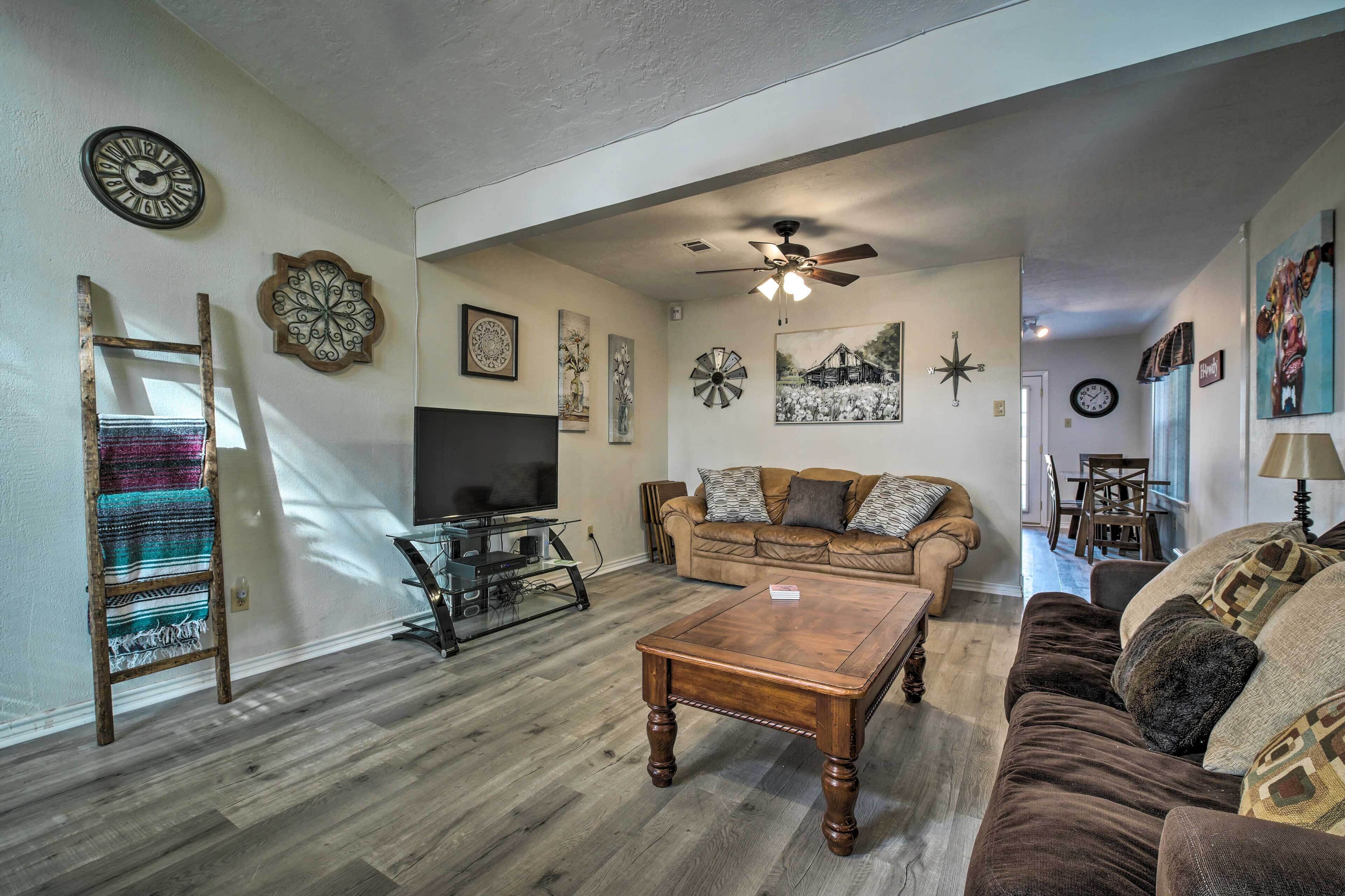 A living room with a wooden coffee table, a television, a sofa, and a ceiling fan.