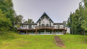 A large, modern house with a prominent balcony and a steeply sloped roof. - Spacious and Lakefront Wasilla Home (Wasilla)